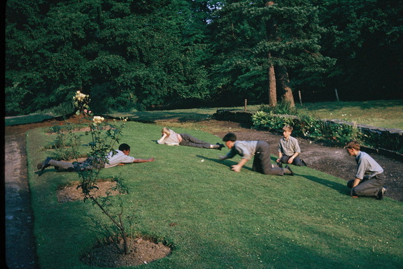 1311.03, JW 6136, 15 Apr 1964, Boys relaxing on the side lawn near the river