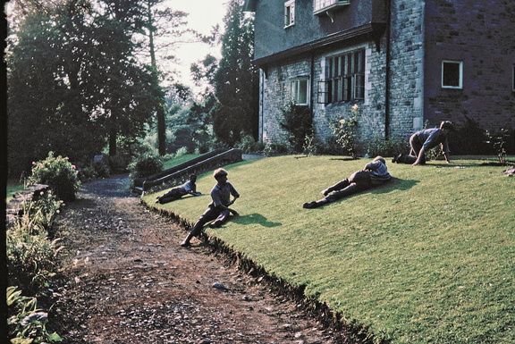 1039.01, JW 6139, 15 Apr 1958, Boys relaxing on the side lawn near the river